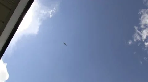 Plane flying overhead and behind roof with lens flare Stock Footage 41668487