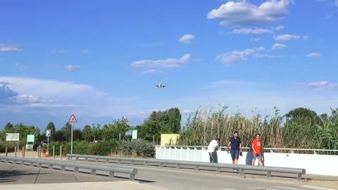 A plane flying overhead as it comes into land at Barcelona - El Prat Airport Stock Footage 121953630