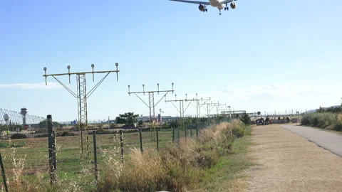 A plane flying overhead as it comes into land at Barcelona - El Prat Airport Stock Footage 121953686