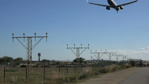 A plane flying overhead as it comes into land at Barcelona - El Prat Airport Stock Footage 121953736