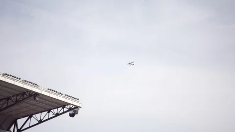 Plane flying by a stadium Stock Footage 102132538