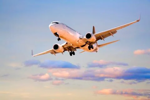 Plane flying in sunset sky Stock Photos