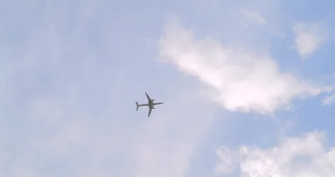 A plane flying through the blue sky with few clouds Stock Footage 252660265