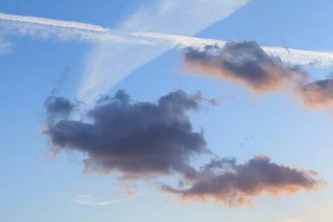 Plane flying through clouds leaving vapour trails. Stock Photos