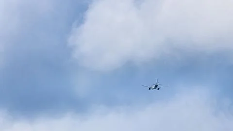 A plane is flying through a cloudy sky Stock Photos