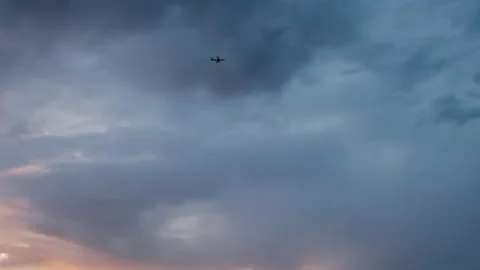 Plane Flying Through Clowdy Sky at Dusk Stock Footage 168759798