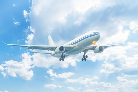 A plane flying through the sky against a background of clouds. Flights and .. Stock Photos
