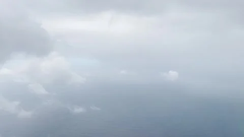 Plane flying through thick clouds to clearing to reveal Faro Stock Footage 243761681