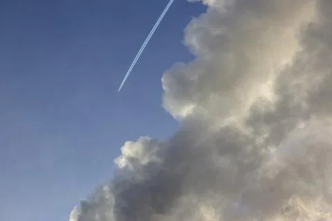 Plane flying from top to bottom with an inversion trail from a large cloud Stock Photos