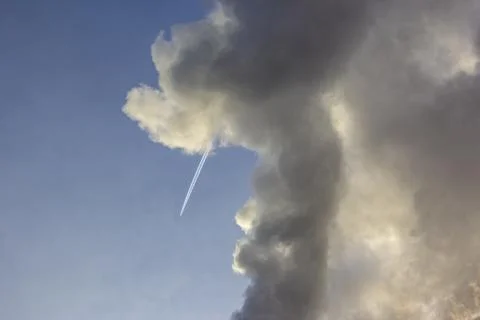 Plane flying from top to bottom with an inversion trail from a large cloud Stock Photos