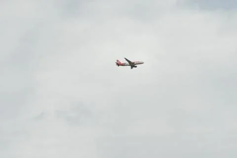 Plane flying under clouds Stock Photos