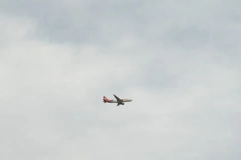 Plane flying under clouds Stock Photos