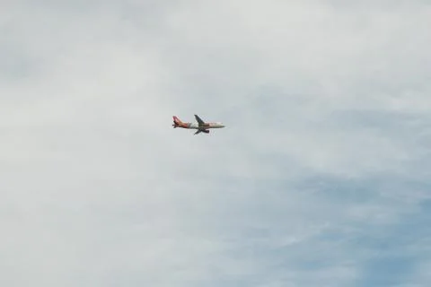 Plane flying under clouds Stock Photos