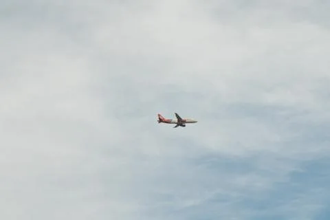 Plane flying under clouds Stock Photos