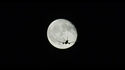 Plane flys through moon 스톡 동영상 100536507
