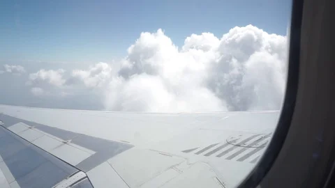 The plane is gaining height in the air, wing above white clouds Stock Footage 129850591