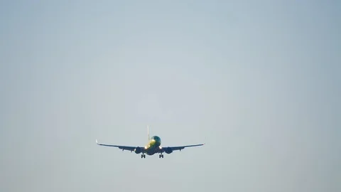 The plane is going down, preparing to land. The plane flies over the camera.  Stock Footage 103565576