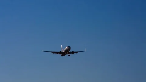 The plane is going down, preparing to land. The plane flies over the camera.  Stock Footage 103565701