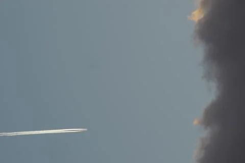 A plane with its smoke trail, at high speed to a cloud Stock Photos