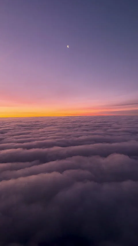 Plane journey above the clouds: crescent moon at sunset on dreamy cloud sea. Stock Footage 301646807