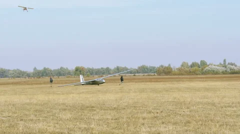 Plane  land on  soil field  with glider and people.  Stock-Footage 56135949