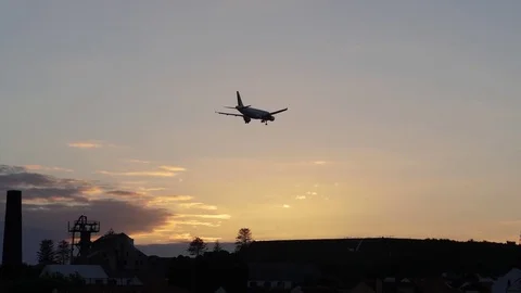 Plane landing at an airport at sunset slow motion Stock Footage