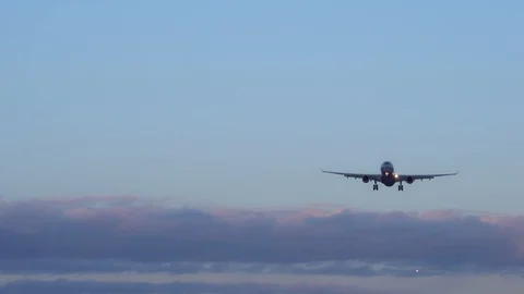 Plane is landing. In background two more aircraft, blue sky purple orange clouds Video stock 105700809