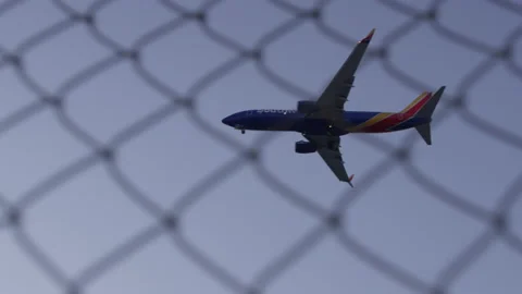 Plane Landing with fence in Foreground Stock Footage 209159394