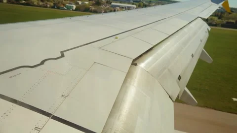 Plane landing on runway. Jet touching down over airfield grass and tarmac Stock Footage 317543772
