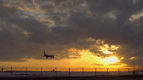 Plane is landing. Sunset, another plane takes off into the sky in the background Video stock 105700871