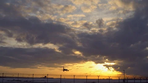 Plane landing. Sunset, blue sky, purple and orange clouds in the background Stock Footage 105701757