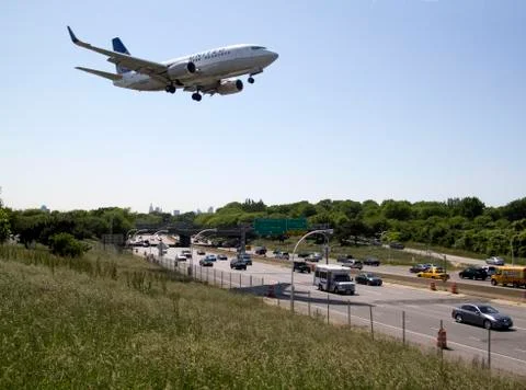 Plane lands low over freeway Stock Photos
