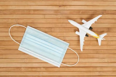 Plane model and face mask on a wooden background with copy space. resumption  Stock Photos
