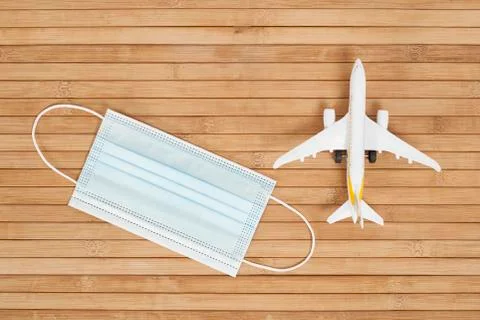 Plane model and face mask on a wooden background with copy space. resumption  Stock Photos