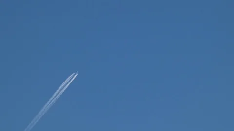 Plane moves through blue sky with trails of white Stock Footage 105424243