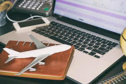 Plane on office computer desktop for aviation transportation business concept Stock Photos