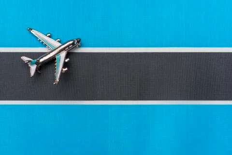 Plane over the flag of Botswana, the concept of journey. Stock Photos