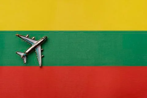 The plane over the flag of Lithuania, the concept of travel. Stock Photos