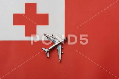 Plane over the flag of Tonga, the concept of journey. Stock Photos
