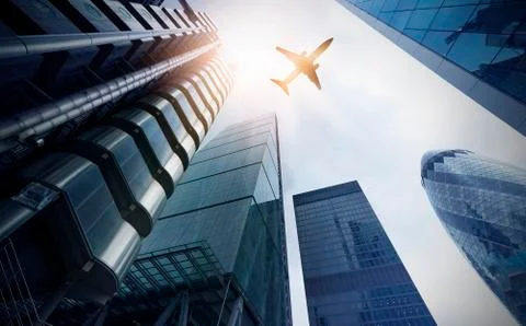 Plane over multiple office towers Foto stock