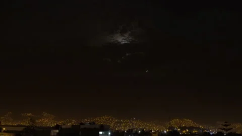 A plane passing close to the bright white full moon covered by clouds Stock Footage 149388812