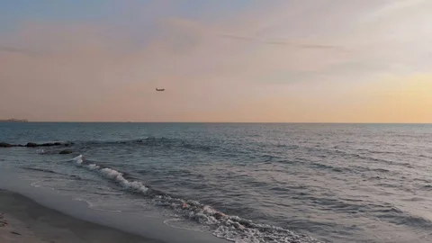 Plane passing over coast line on sunset 库存影片 107361045