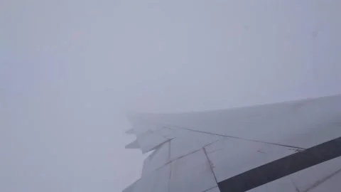 Plane passing through thick clouds while climbing, wing view of emirates flight Stock Footage 324883254