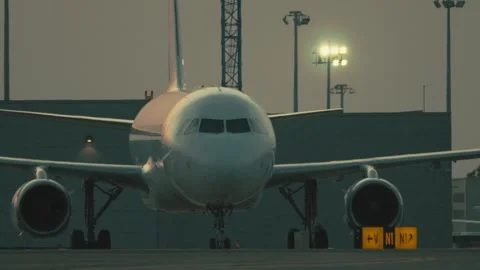 Plane prepares for takeoff at sunset while standing on the runway with bright Stock Footage 335477408