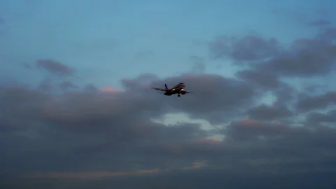 The plane is preparing to go for landing. Evening, dark blue and purple clouds Video stock 105702090
