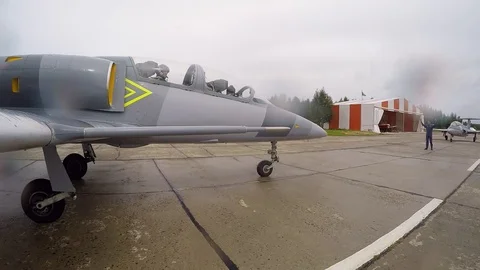 Plane pulls up and stops in front of Landing Signal Officer. Man gives a signal. Stock Footage 118676690