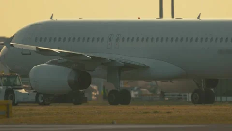 Plane on the runway during sunset at the airport with ground crew preparing for Stock Footage 335545669