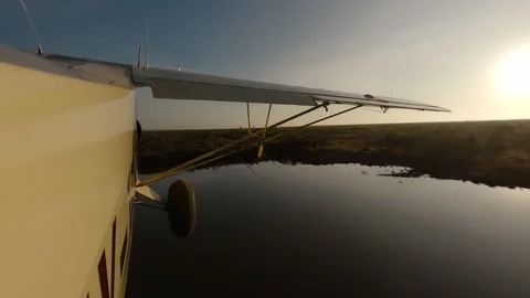 Plane side view flying low over river at sunny morning Stock Footage 310977413