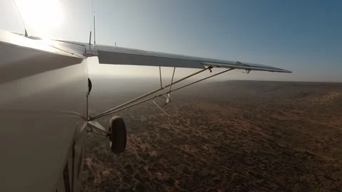 Plane side view flying over dry savannah at morning Stock Footage 310968297
