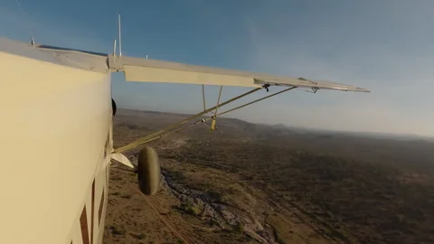 Plane side view flying over dry savannah at morning Stock Footage 310969918